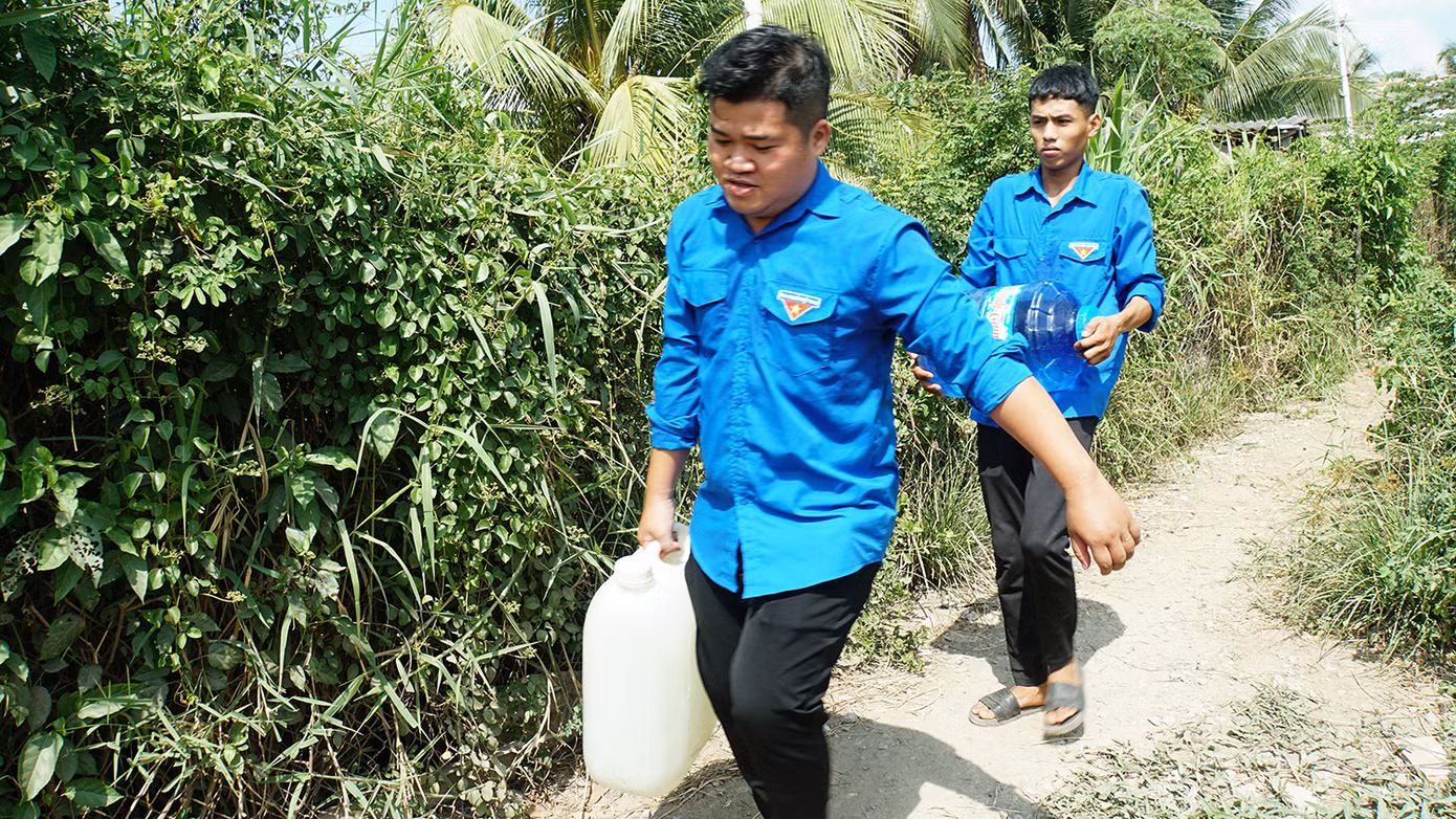 Các bạn trẻ mang nước trực tiếp đến tận nhà giúp dân. Ảnh: Hòa Hội