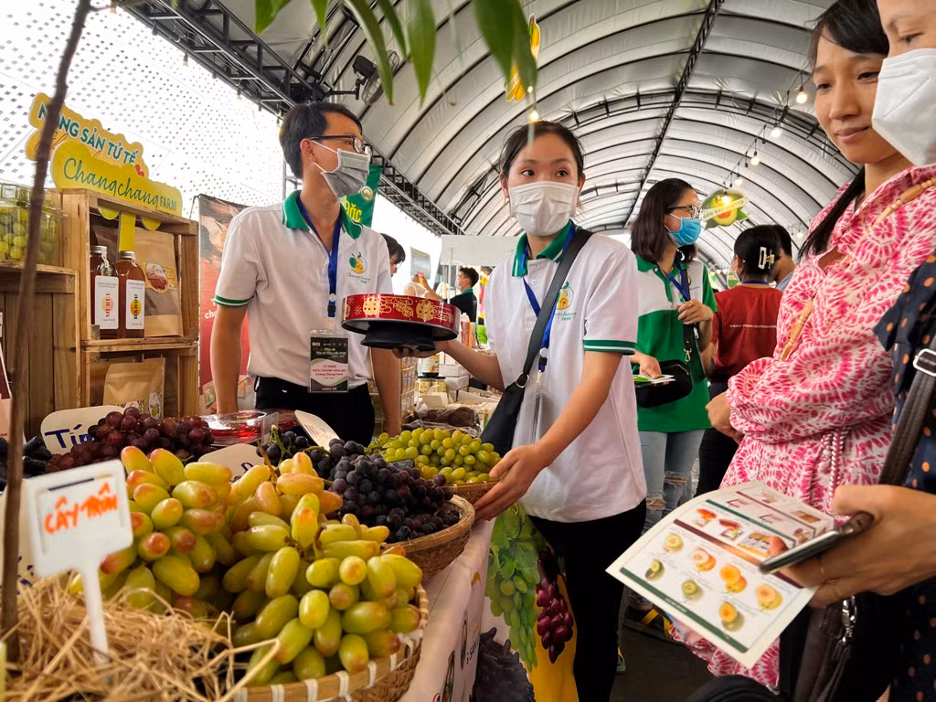 Khách xếp hàng dùng thử đặc sản nho tại phiên chợ.