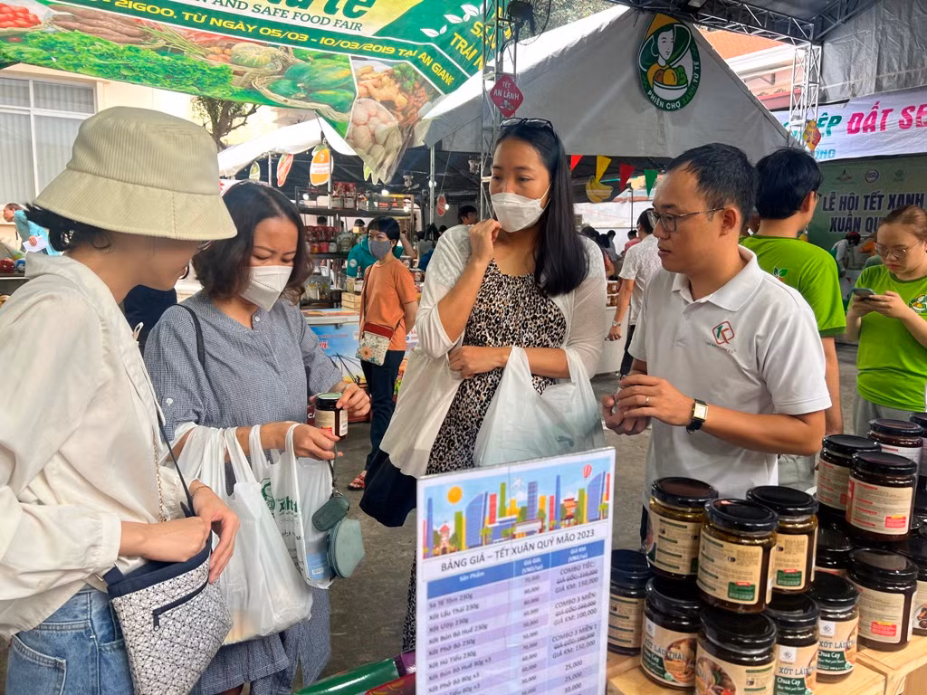 Anh Văn Long (bìa phải) nhiệt tình giới thiệu các loại xốt gia vị đến các khách hàng nữ