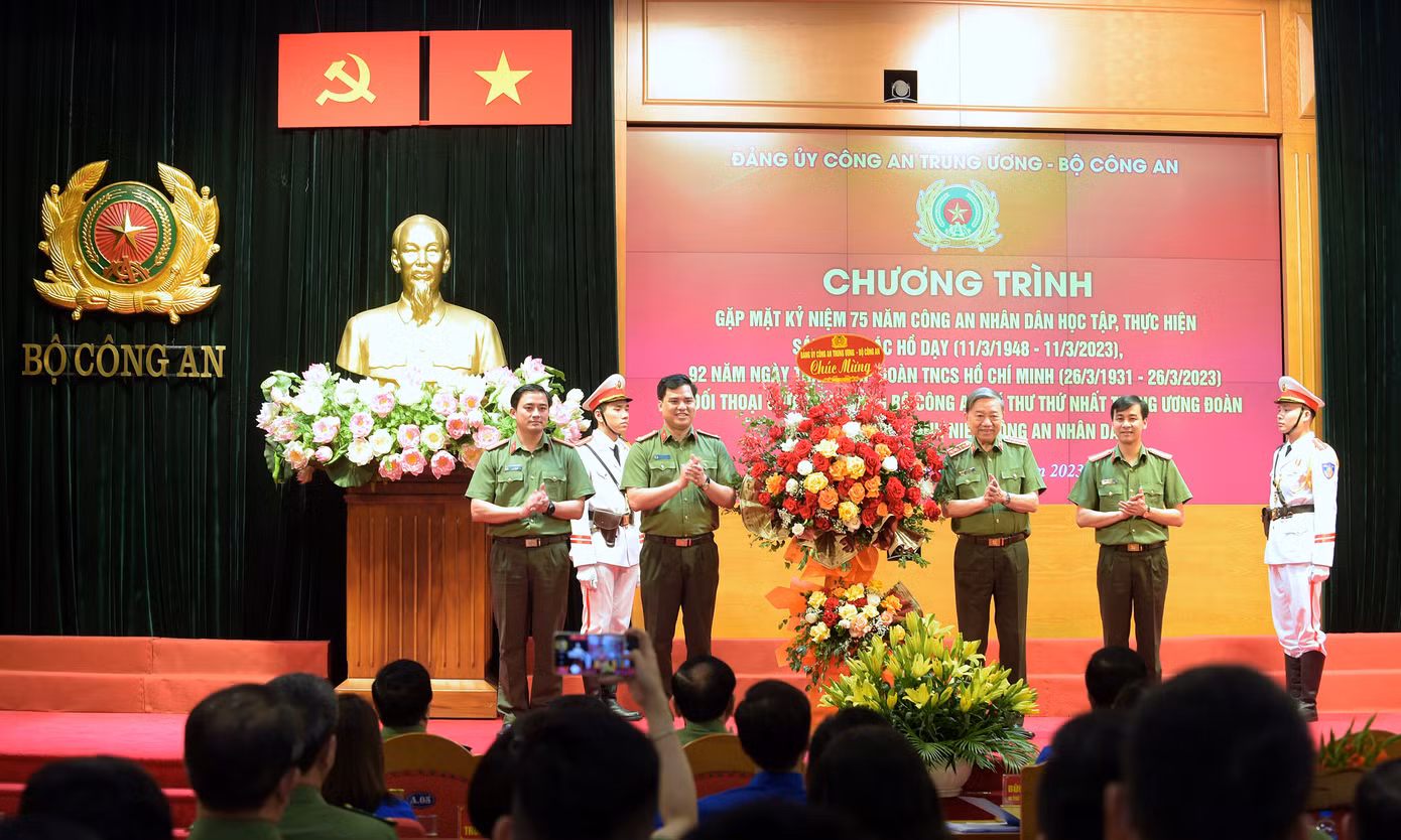 Bộ trưởng Tô Lâm tặng hoa chúc mừng Ban Thanh niên Công an. Ảnh: Xuân Tùng