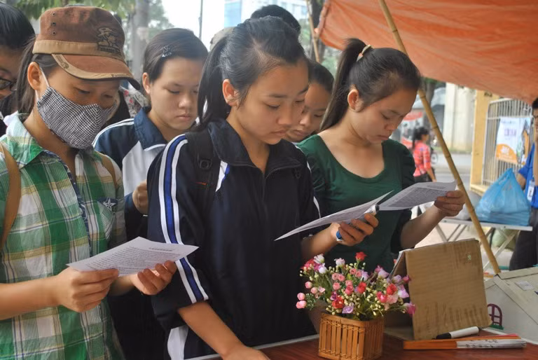 Sinh viên đọc phiếu tìm hiểu về cơm chay trước khi mua cơm