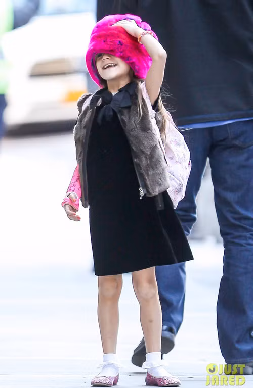 Suri Cruise điệu đà đến trường với mũ và giày hồng. Chiếc mũ lông đáng yêu của cô bé khiến nhiều fan thích thú, chưa kể phần bó bột ở tay Suri cũng được 