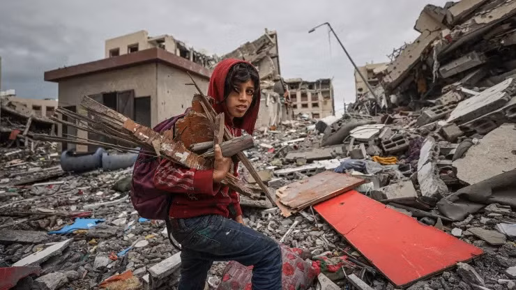 Một đứa trẻ Palestine đi giữa hoang tàn đổ nát sau trận không kích của Israel vào Dải Gaza. Ảnh: Anadolu.