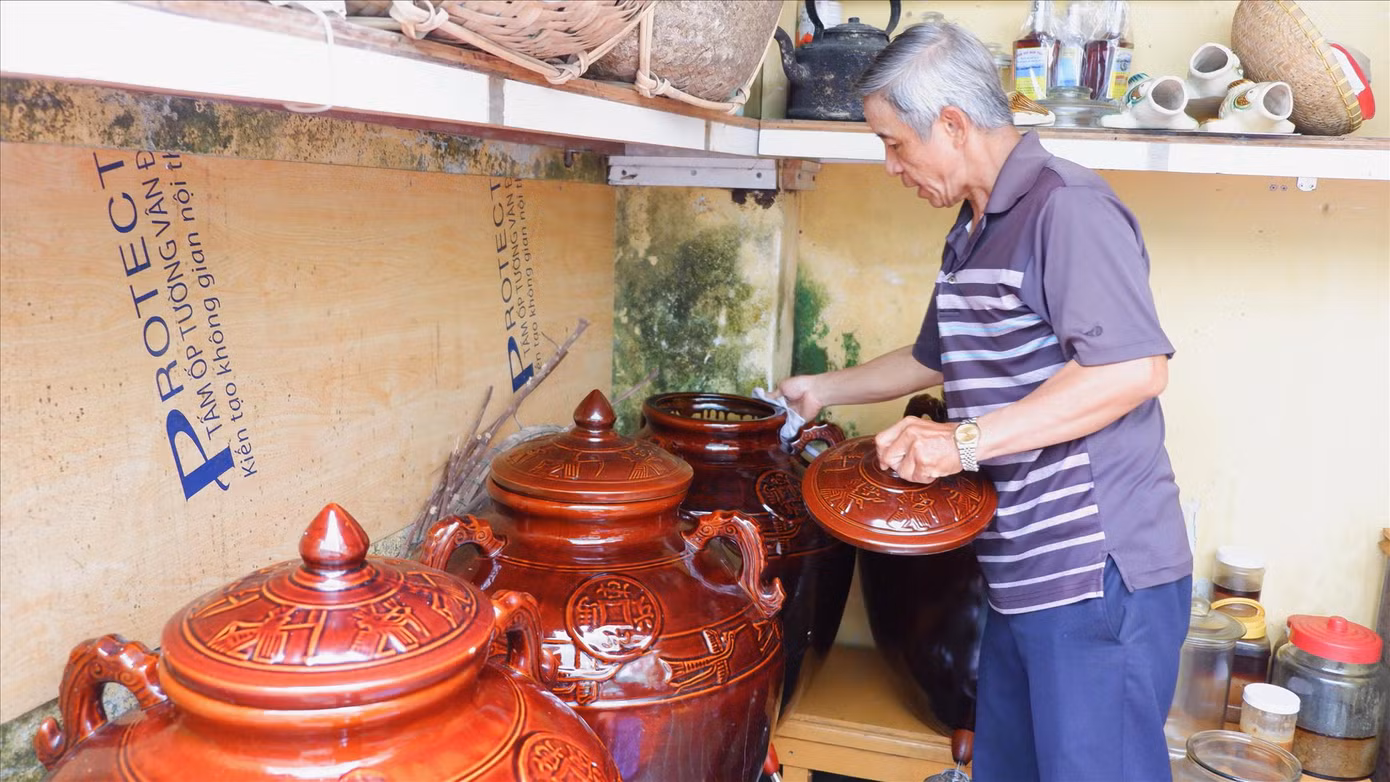 Ông Mười chăm chút những chum mắm để đảm bảo sạch sẽ nhất Ảnh: Nguyễn Thành
