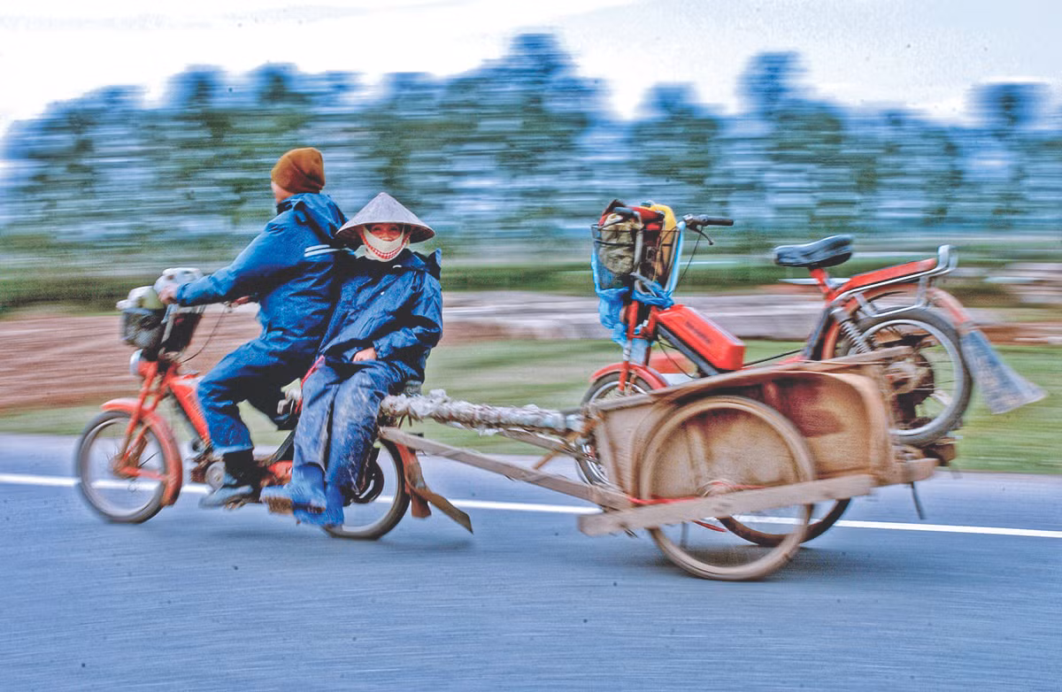 Một cặp vợ chồng ở ngoại thành Hà Nội đang trên đường về nhà sau khi chở hàng vào nội thành. Để tiết kiệm xăng, người chồng chở cả vợ và xe của vợ ở phía sau