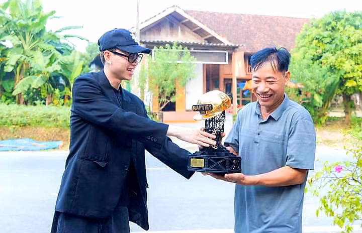 Ông Bùi Văn Tường đón cup Quán quân Rap Việt từ tay con trai.