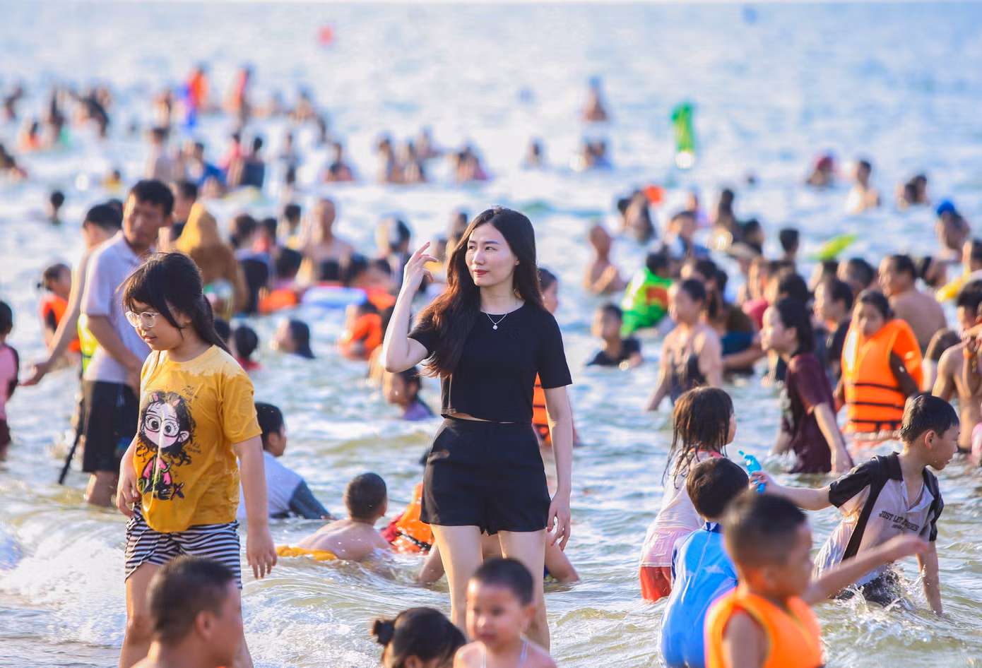 Bãi biển phủ kín người nên nhiều bạn trẻ không chen chúc tắm mát mà đứng cạnh bãi tắm.