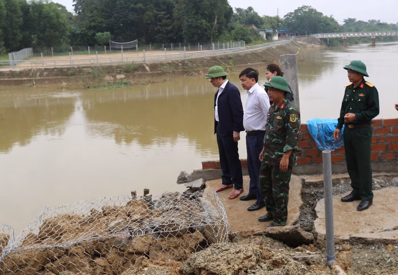 Kiểm tra hiện trường vụ sạt lở, ông Nguyễn Văn Thành - Bí thư Huyện ủy Cẩm Xuyên (ngoài cùng bên trái) cho biết, trước mắt, huyện huy động các lực lượng triển khai khắc phục tạm thời sự cố sạt lở để đảm bảo cuộc sống và tài sản cho người dân xã Cẩm Duệ. Về lâu dài, huyện đã đề xuất tỉnh hỗ trợ gói khẩn cấp khắc phục thiên tai với kinh phí 15 tỷ đồng để xây kè kiên cố chống mưa lũ".