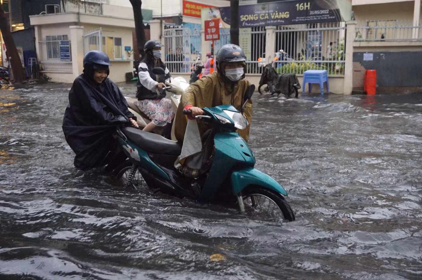 Người dân vất vả đẩy xe máy qua tuyến đường ngập ở Thảo Điền.