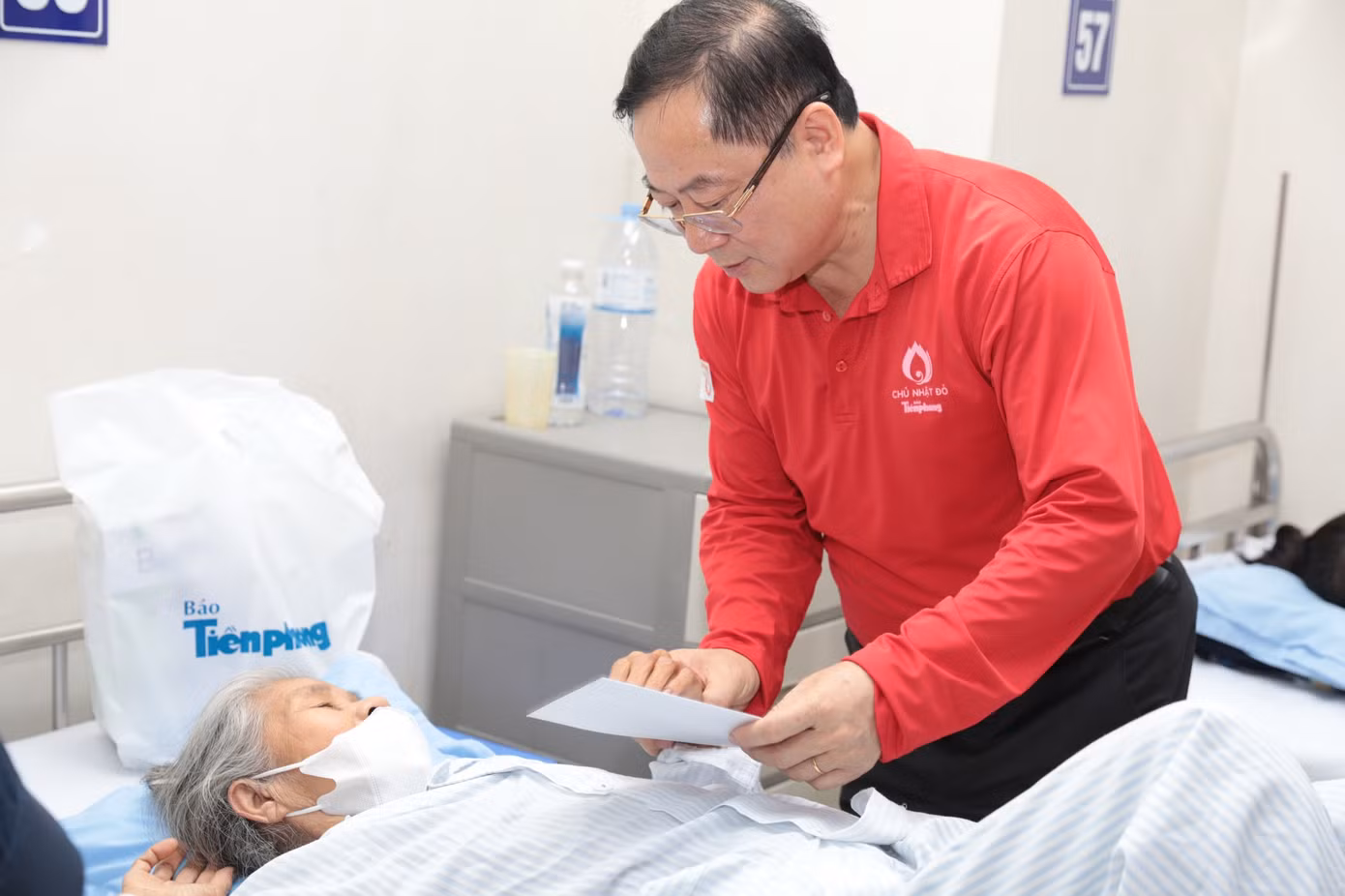 Nhà báo Lê Xuân Sơn - Tổng Biên tập báo Tiền Phong thăm hỏi, động viên bệnh nhân đang điều trị tại Viện Huyết học - Truyền máu Trung ương. Ảnh: Hồng Vĩnh