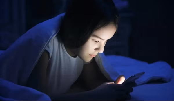 Nhiều người còn có thói quen dùng điện thoại ngay trước khi đi ngủ, vậy mà vẫn không mơ thấy điện thoại. Ảnh: kryhov/ Shutterstock.