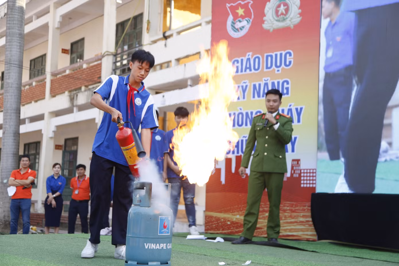 Công an hướng dẫn học sinh sử dụng phương tiện chữa cháy. Ảnh: Nguyễn Thắng