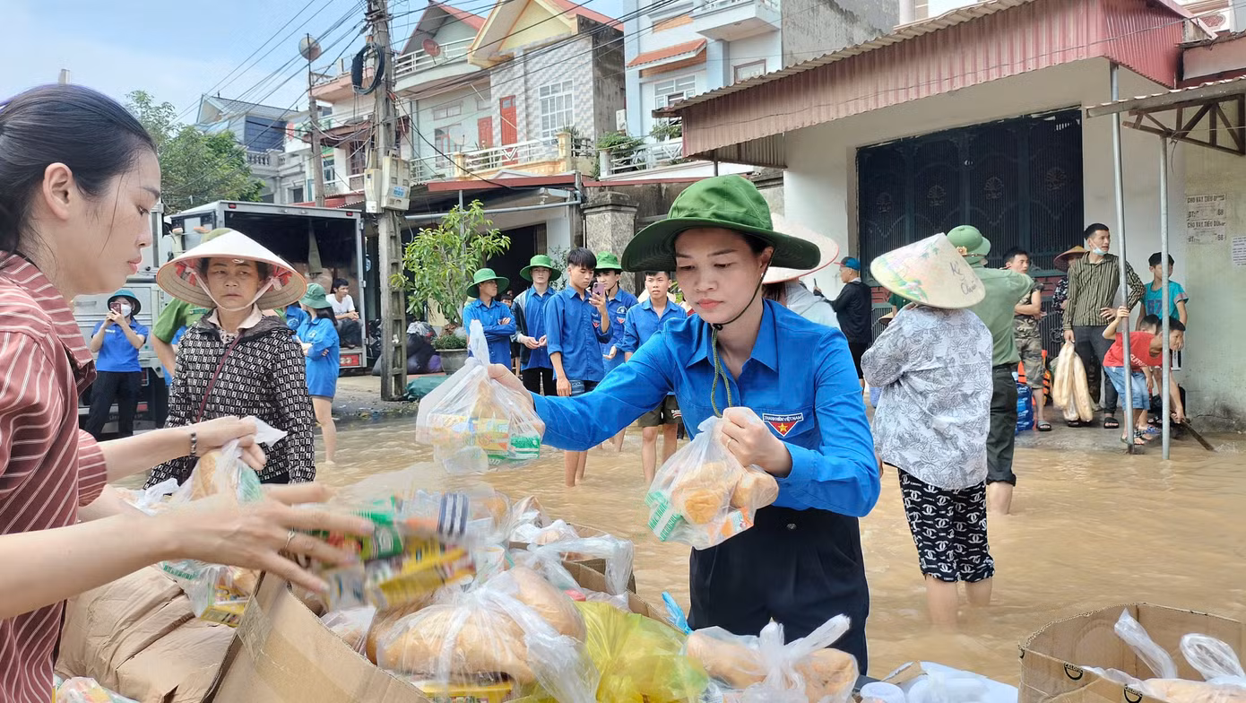 Chị Nguyễn Thị Hương - Bí thư Huyện Đoàn Yên Dũng (Bắc Giang) tiếp tế lương thực, thực phẩm cho bà con vùng lũ. Ảnh: Nguyễn Thắng