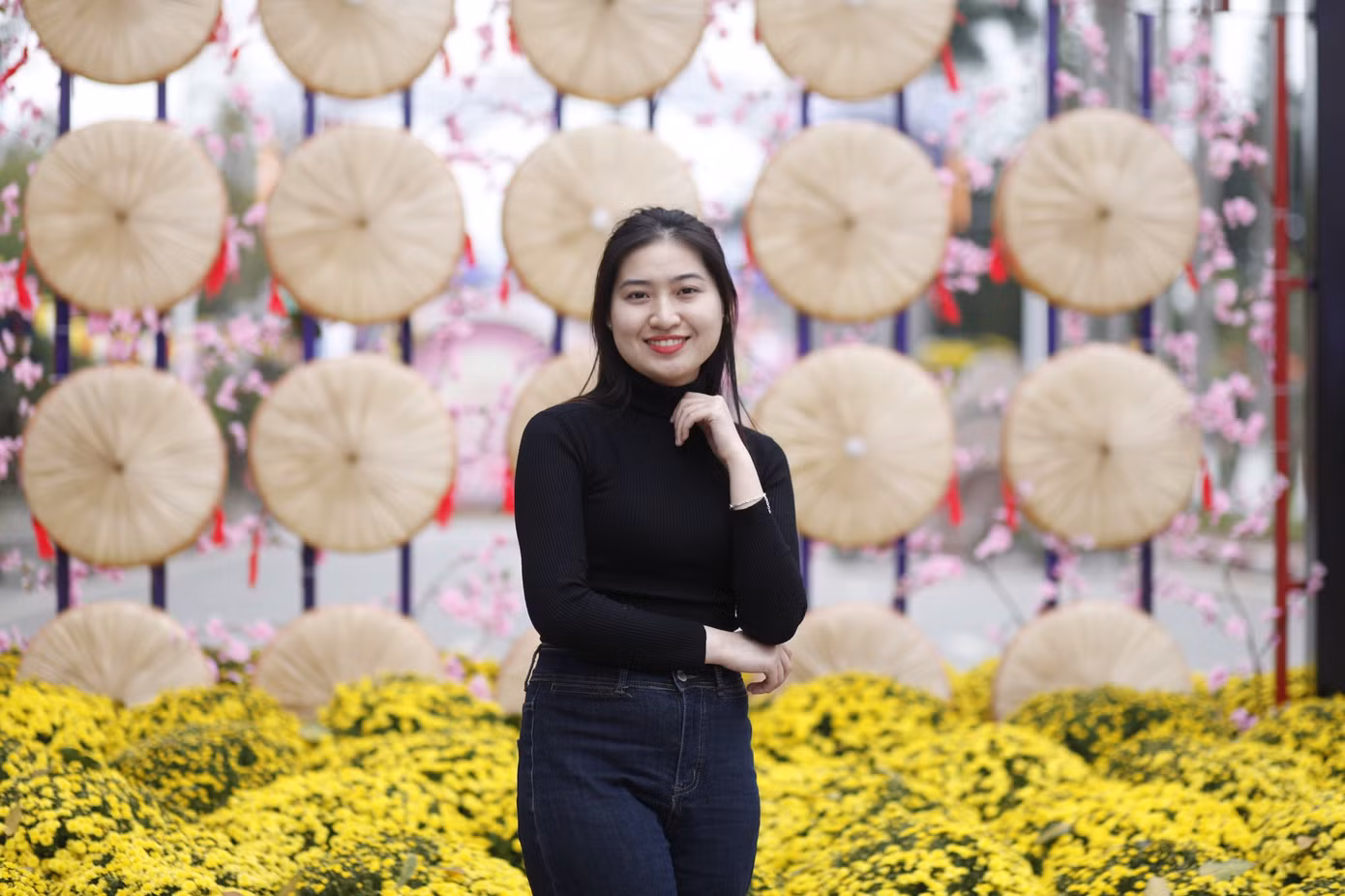 Các bạn trẻ chụp ảnh lưu niệm tại mô hình nón quai thao ở đường hoa Tết. Ảnh: Nguyễn Thắng