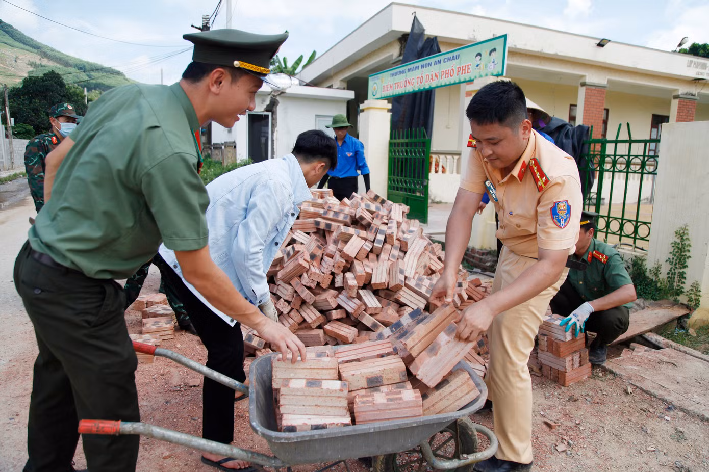 Cán bộ, chiến sĩ Ban Thanh niên Công an tỉnh Bắc Giang vận chuyển gạch hỗ trợ người dân xây nhà mới. Ảnh: Nguyễn Thắng