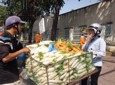 Một xe bán rau củ lề đường cạnh tranh giá cả với các sạp hàng ở trong chợ. Thời buổi khó khăn, nhiều người tiết kiệm đến cả các khoản mua thực phẩm thiết yếu hàng ngày
