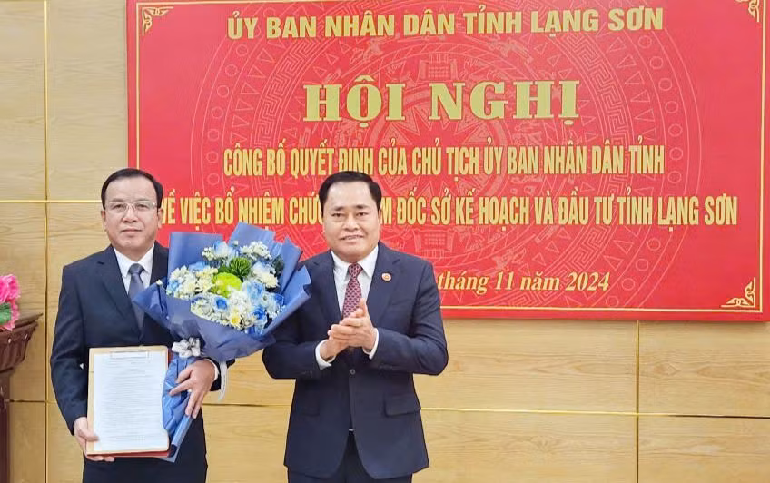Ông Phan Hồng Tiến (bìa trái) nhận quyết định, hoa chúc mừng của Chủ tịch UBND tỉnh Lạng Sơn Hồ Tiến Thiệu (ảnh: Duy Chiến)