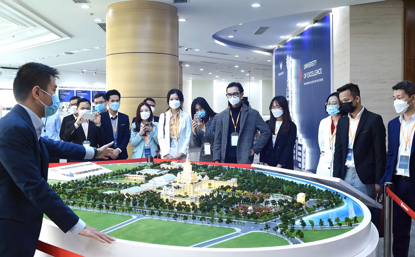 Đoàn đại biểu nghe giới thiệu tổng quan bên sa bàn của Trường, trước khi đến thăm thư viện, các phòng nghiên cứu, sáng tạo.