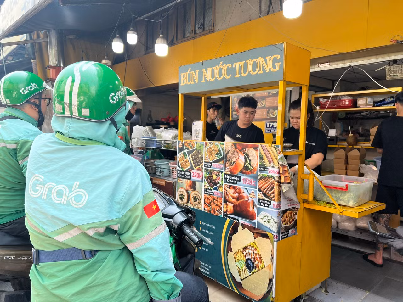 Tại một quán ăn tại khu phố ẩm thực (quận 3), rất đông tài xế giao hàng công nghệ đang chờ đợi nhận món ăn theo đơn hàng của thực khách. "Sáng giờ tôi đã chạy gần 20 đơn hàng ẩm thực đa số đều là món ăn chay, có đơn lên đến hơn 10 phần. Trong ngày này, khách rất đông nên có nơi, tôi chờ đợi gần 30 phút mới đến lượt" - anh Trần Văn Bảy (46 tuổi), tài xế công nghệ cho biết.