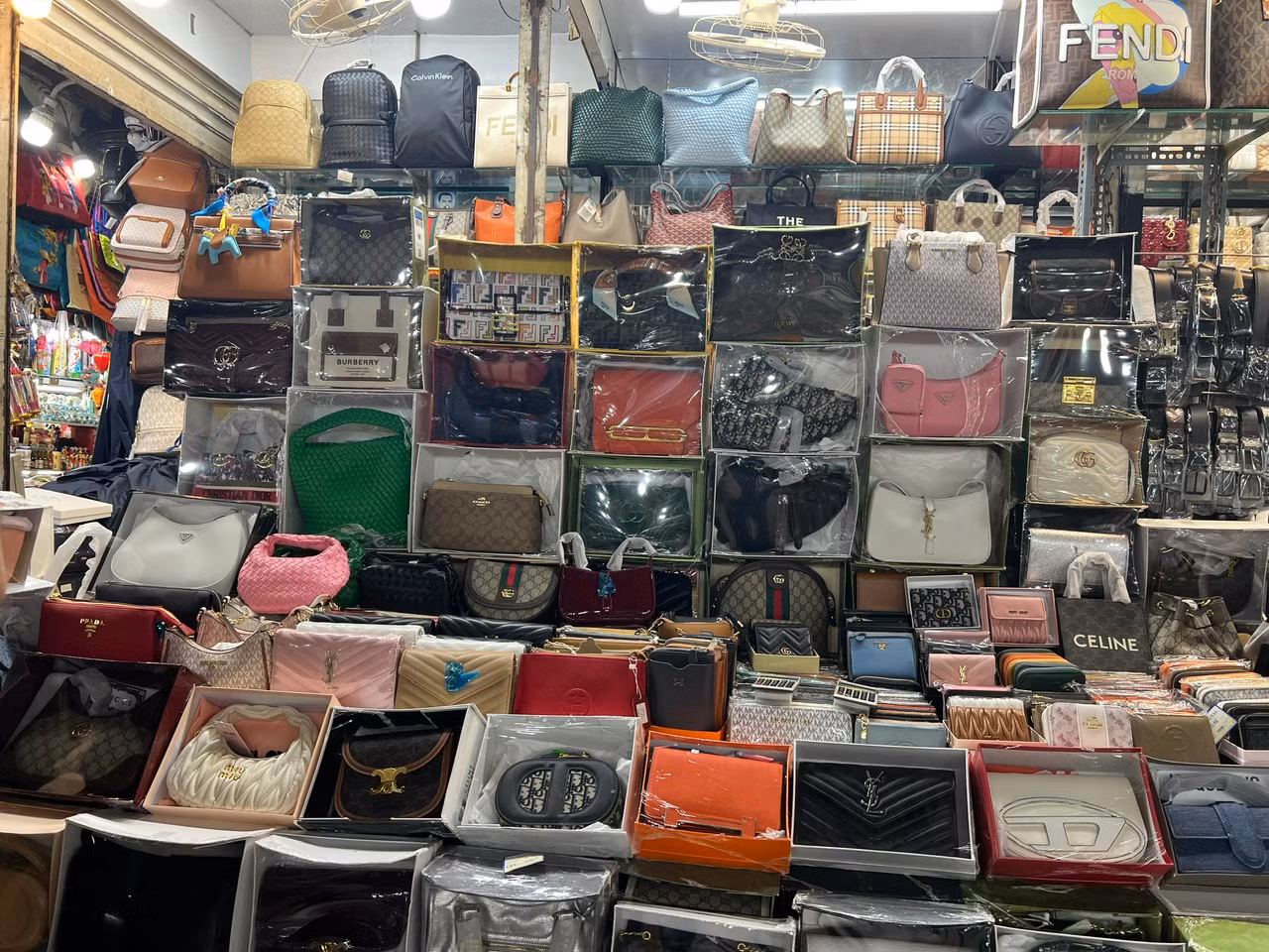Tại chợ Bến Thành (quận 1), túi xách thời trang gắn nhiều thương hiệu như Dior, LV, YSL, Celine... được bán với giá từ 300.000 đồng/cái và còn có thể giảm giá.