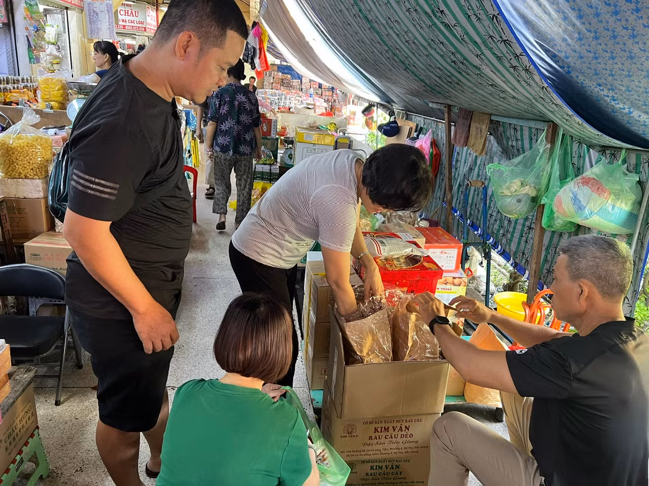 Tiểu thương liên tục khui những thùng hàng mới để châm lên quầy sạp. "Cách đây khoảng một tuần, khách đến mua sắm vẫn còn thưa thớt thì nay đã nhộn nhịp hơn. Đặc biệt nhiều đoàn khách du lịch từ nước ngoài đến tham quan cũng mua sắm. Chúng tôi tranh thủ bán trong khoảng 3 ngày cao điểm Tết, đến 29 tháng Chạp là dọn dẹp, đóng quầy để đón Tết" - chị Hiền, tiểu thương kinh doanh thực phẩm khô chia sẻ.