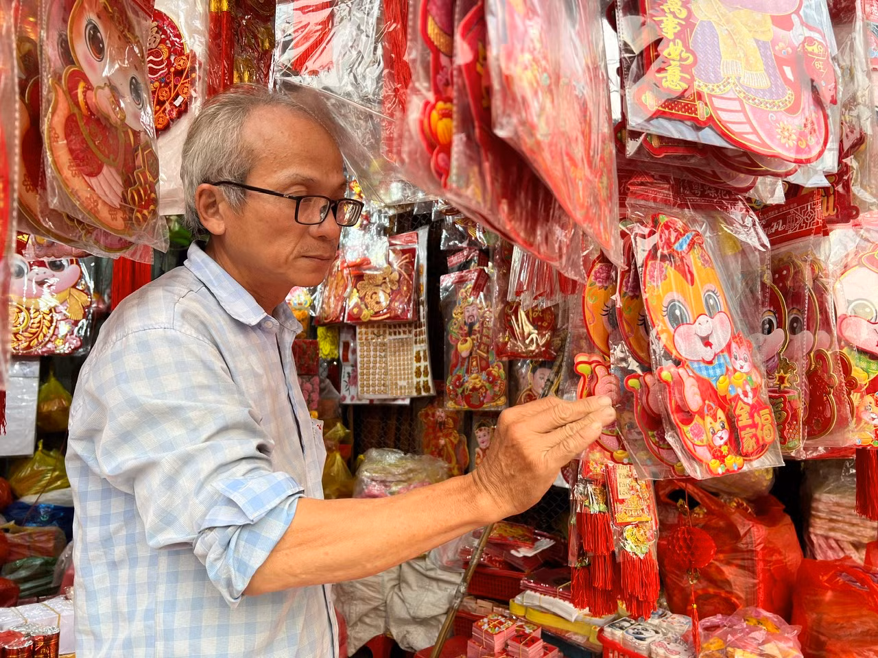 Ông Kha Tùng Kiên, chủ cửa hàng Chi Sây đang chăm chút cho từng sản phẩm chờ đón khách. "Mọi năm tôi bán đến tận 1 - 2 giờ sáng, còn bây giờ chỉ tới 22 giờ là đã không còn khách. Sức mua khá chậm" - ông Kiên nói.