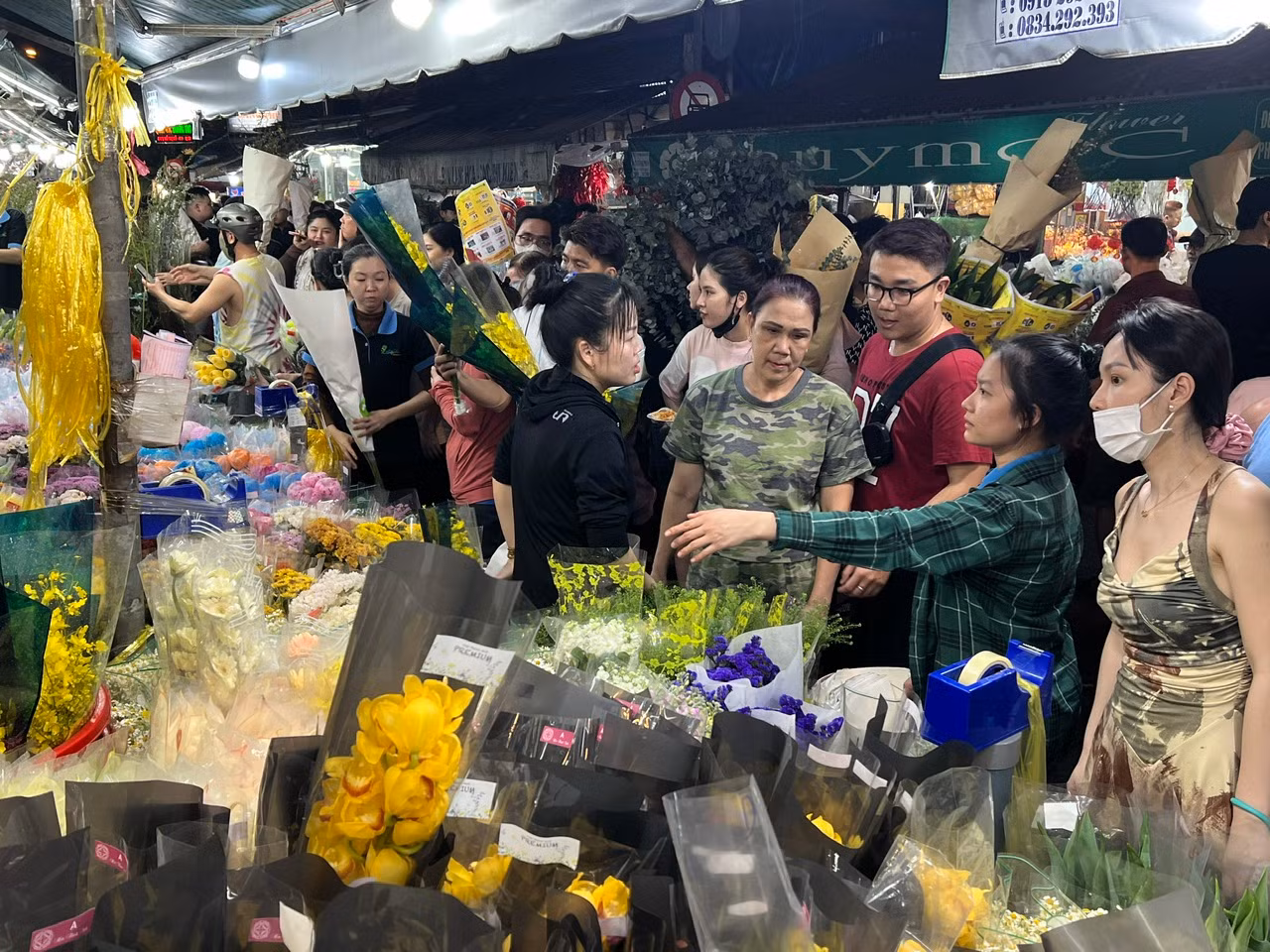 Nửa đêm ngày 26/1(27 tháng Chạp), tại chợ hoa Hồ Thị Kỷ (quận 10, TPHCM), khách mua hoa vẫn nhộn nhịp, tấp nập. Đây là chợ hoa đầu mối lớn nhất TPHCM, đáp ứng mọi nhu cầu chơi hoa của người dân. Giá cả ở đây đều được niêm yết công khai, người mua không nói thách, người bán cũng không trả giá.