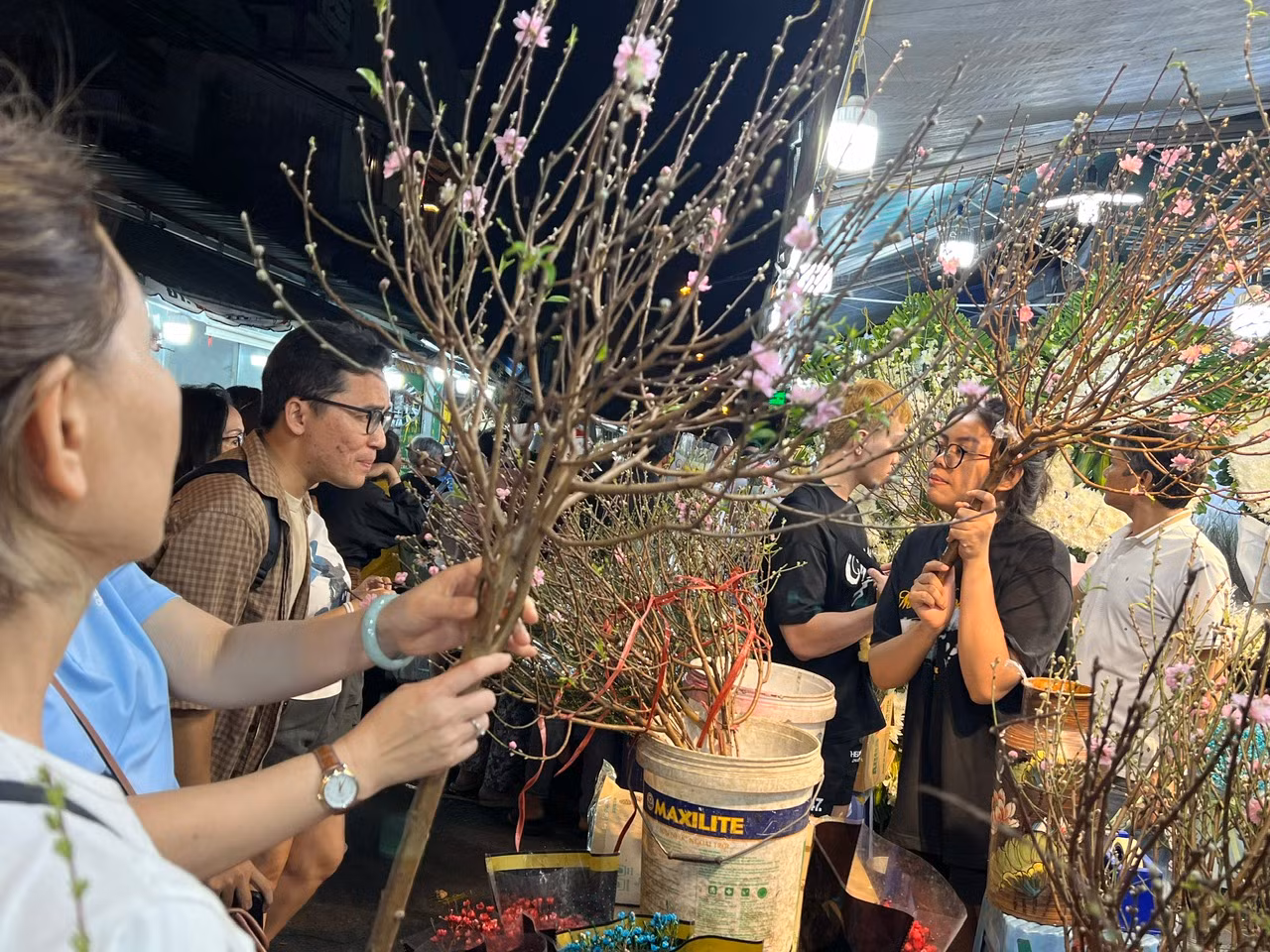 Đa số khách không cò kè trả giá mà mua ngay khi chọn được cành đào ưng ý bởi chỉ cần bỏ xuống liền có người khác mua. "Hôm nay cửa hàng đã bán gần cả trăm cành đào do mặt hàng này đang hút khách nên có thể vào ngày mai, bên em sẽ cháy đào cắt cành" - chị Trang, nhân viên một tiệm hoa cho biết.