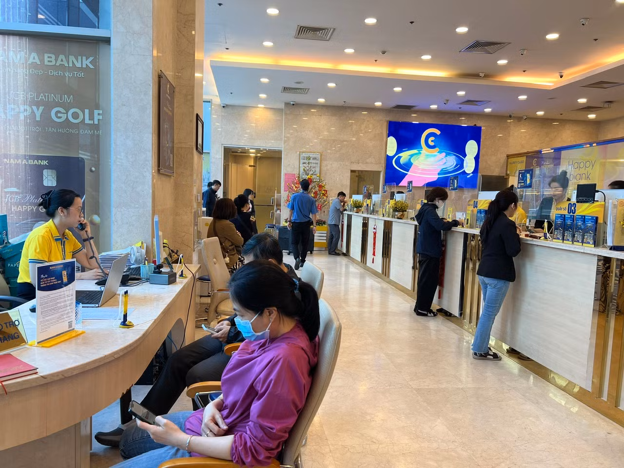 Tại Ngân hàng Nam Á trên đường Cách Mạng Tháng Tám (quận 3), nhân viên không nghỉ trưa để phục vụ khách. Tuy nhiên khách hàng vẫn phải chờ đợi khá lâu chứ không thể đến quầy hỗ trợ ngay.