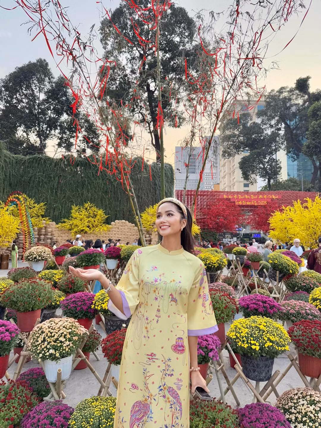 Hoa hậu H'Hen Niê khoe sắc với áo dài ở hội chợ xuân.