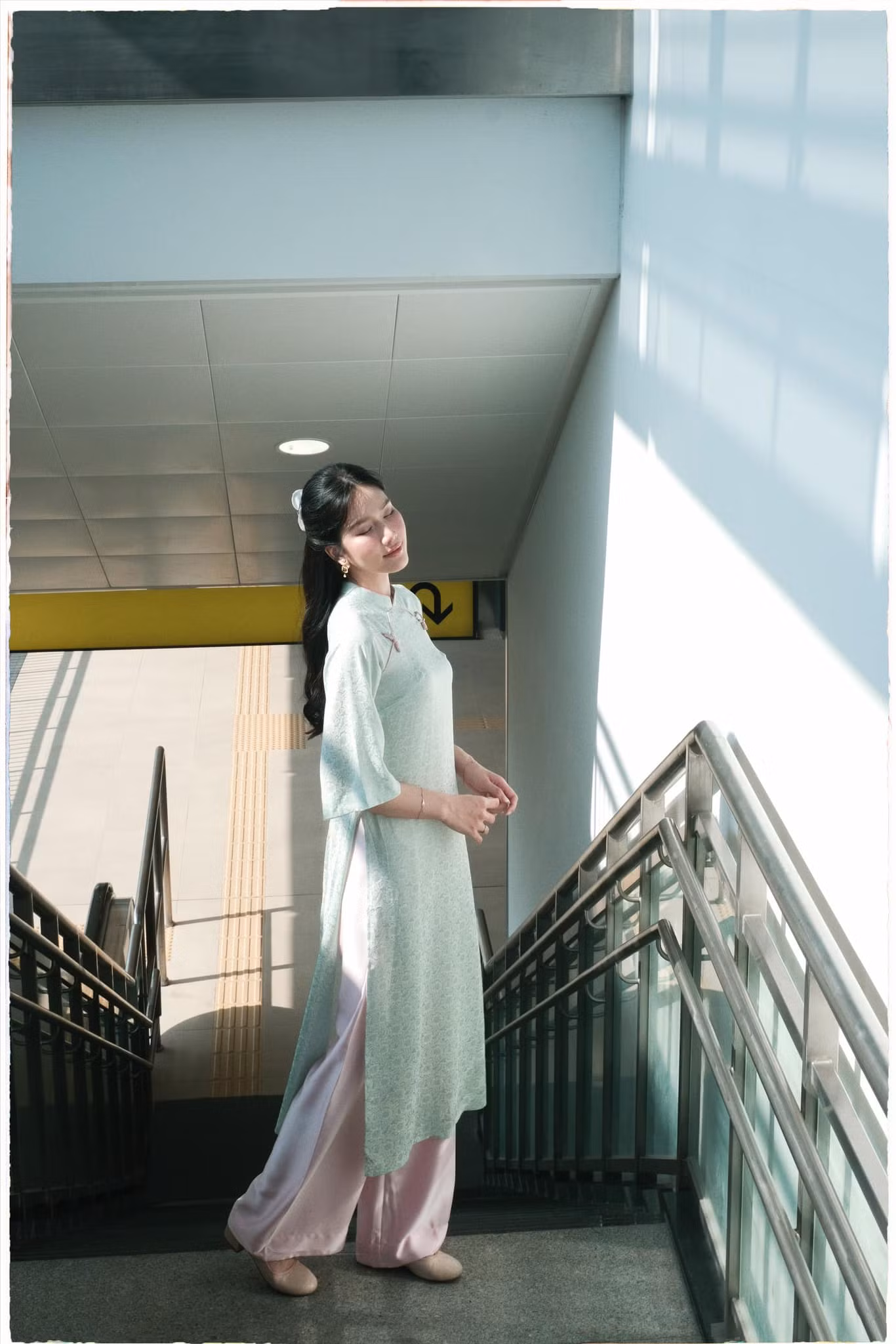 Á hậu Phương Anh ưa chuộng áo dài dáng suông, gam màu pastel nhẹ nhàng. Cô phối cùng phụ kiện giày bệt, kẹp tóc mang phong cách vintage.