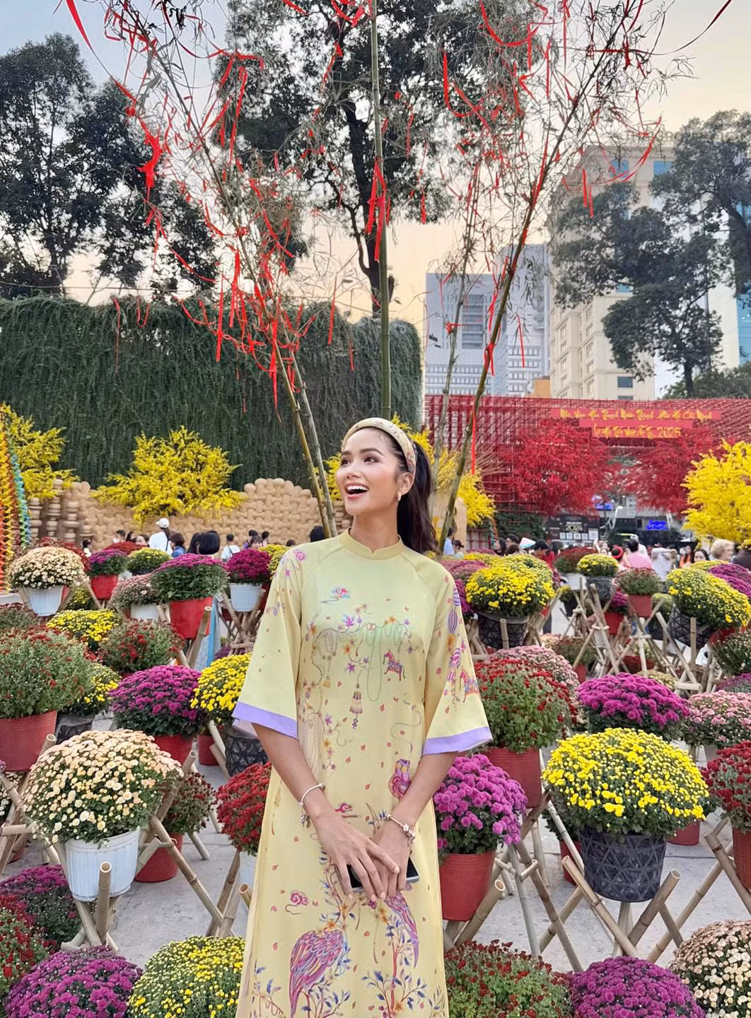 Hoa hậu H'Hen Niê khoe sắc với áo dài ở hội chợ xuân.
