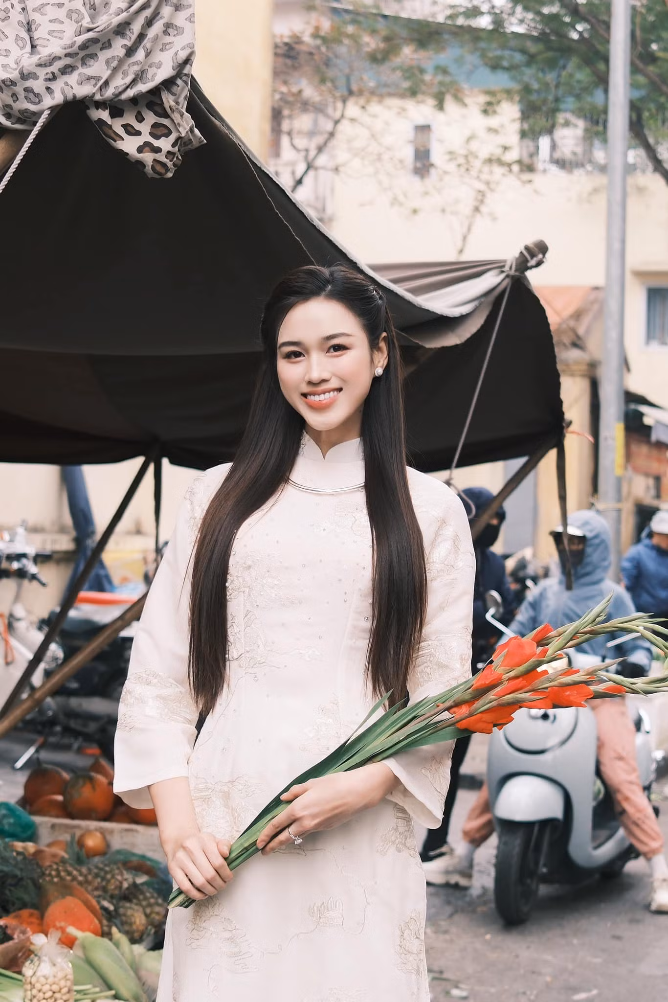 Hoa hậu Đỗ Thị Hà diện áo dài trắng họa tiết đi chợ Xuân những ngày cận Tết. Cô mặc áo dài lụa, kiểu dáng suông, tông màu nền nã.