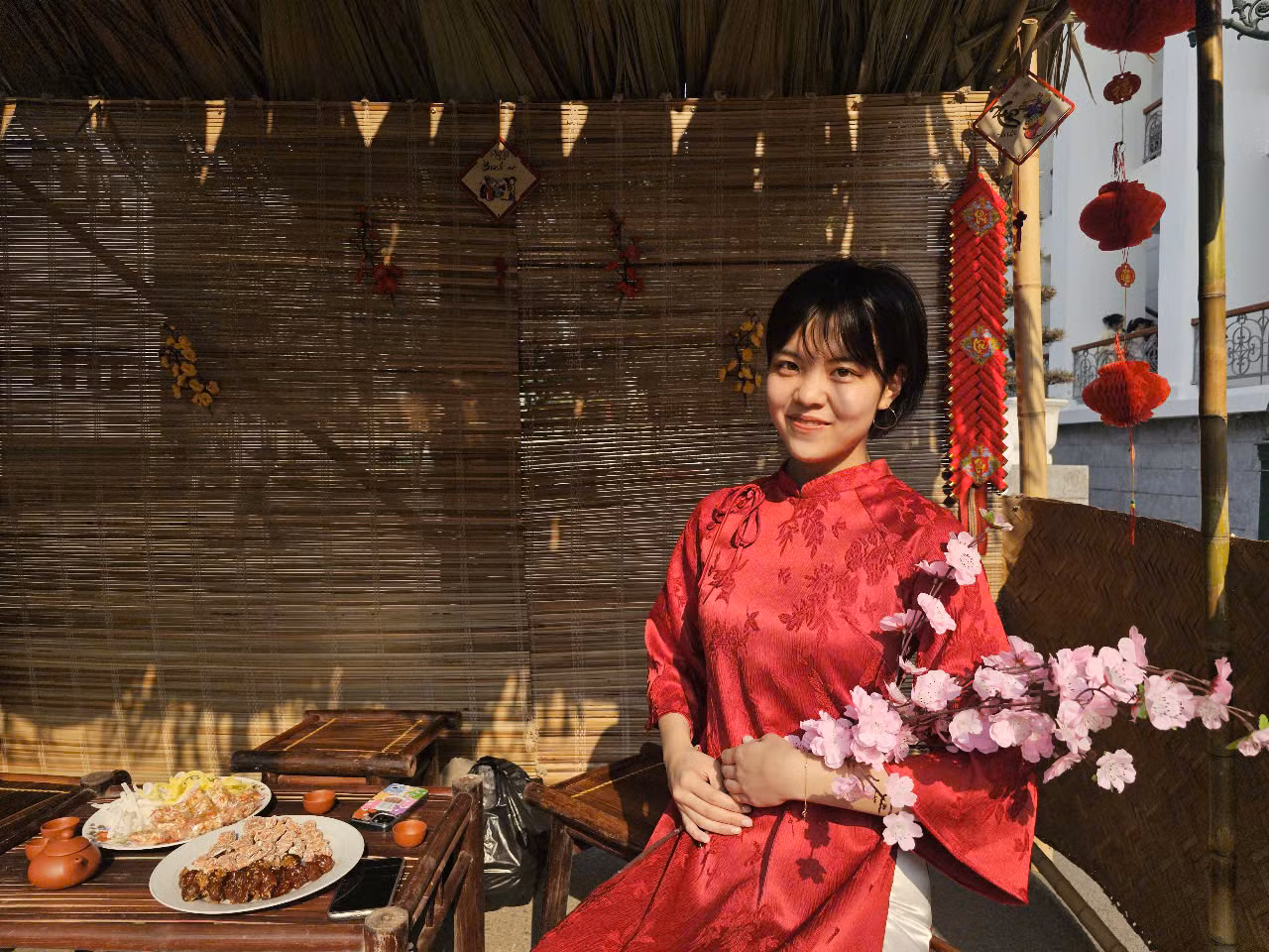 Saku duyên dáng trong bộ áo dài đỏ.