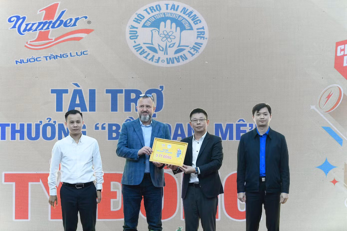 Bí thư T.Ư Đoàn Nguyễn Minh Triết và Phó Trưởng Ban Tuyên giáo T.Ư Đoàn Đỗ Công Tuân chứng kiến ông Andrzej Tomasz Bialasiewicz - Tổng Giám đốc Marketing Công ty TNHH sản xuất thương mại dịch vụ Number One trao biển tượng trưng nguồn lực hỗ trợ giải thưởng tới Quỹ Hỗ trợ Tài năng trẻ Việt Nam.