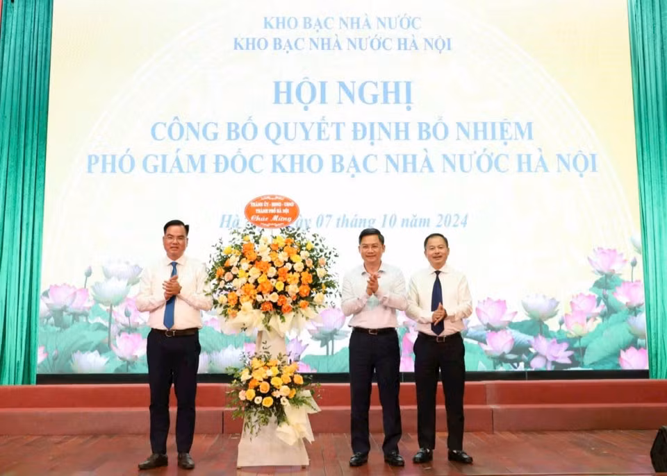 Phó Chủ tịch UBND TP. Hà Nội Hà Minh Hải tặng hoa chúc mừng hai tân phó giám đốc Kho bạc Nhà nước Hà Nội. Ảnh: T.G
