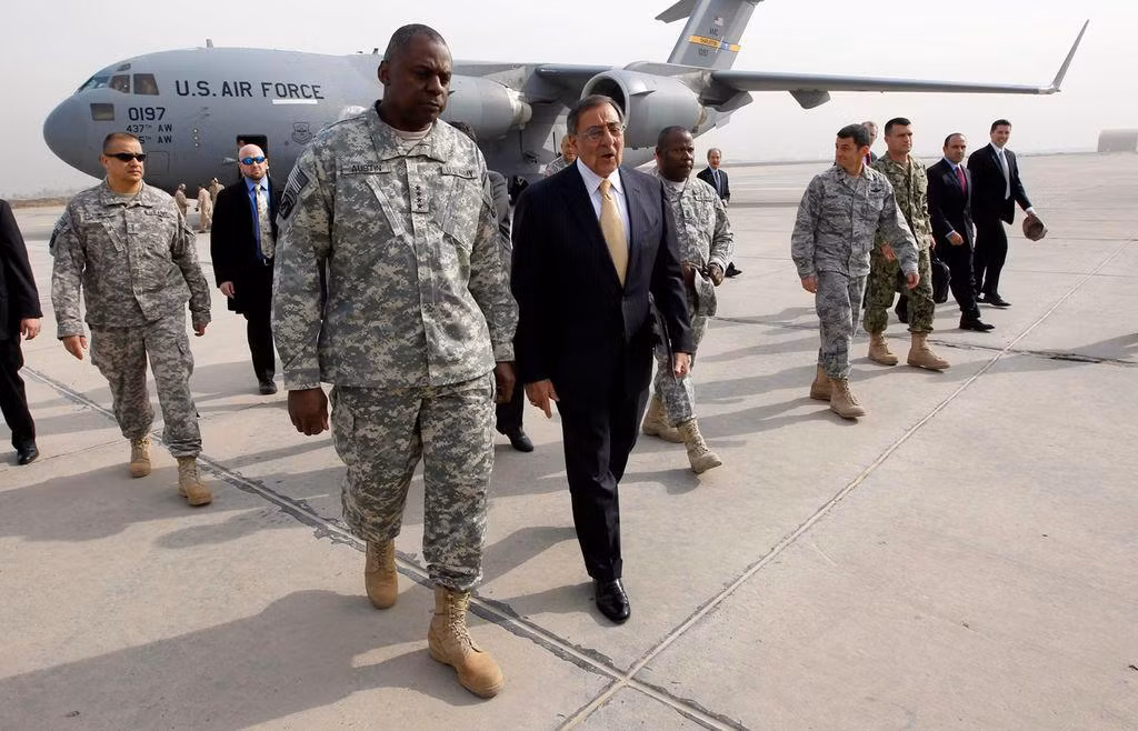 Tướng lục quân Lloyd Austin (hàng đầu, bên trái) tháp tùng Bộ trưởng Quốc phòng Mỹ Leon Panetta tới thăm thủ đô Baghdad của Iraq hồi tháng 12/2011. Ảnh: Boston Globe.