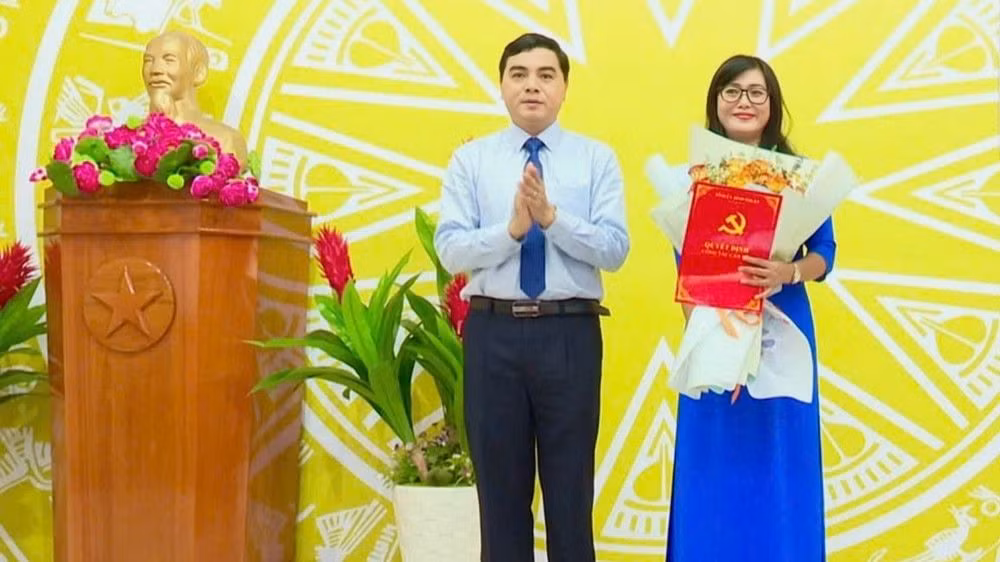 Ông Nguyễn Hoài Anh - Bí thư Tỉnh ủy Bình Thuận trao quyết định, tặng hoa chúc mừng bà Nguyễn Thị Minh Hoàng.