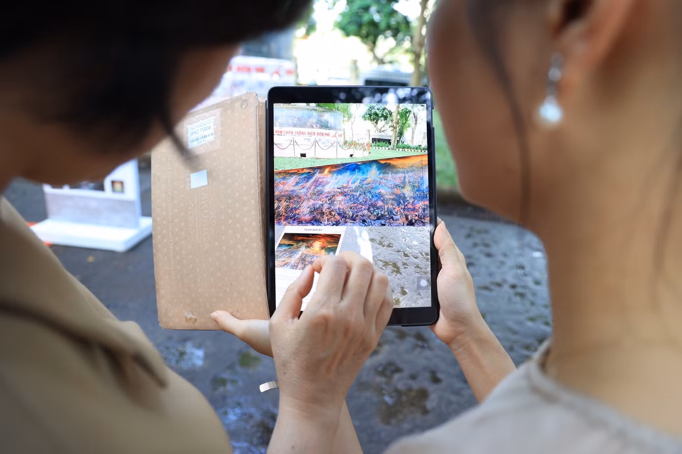 Du khách sử dụng điện thoại, máy tính bảng quét mã QR và trải nghiệm công nghệ AR ẩn trong bức tranh.