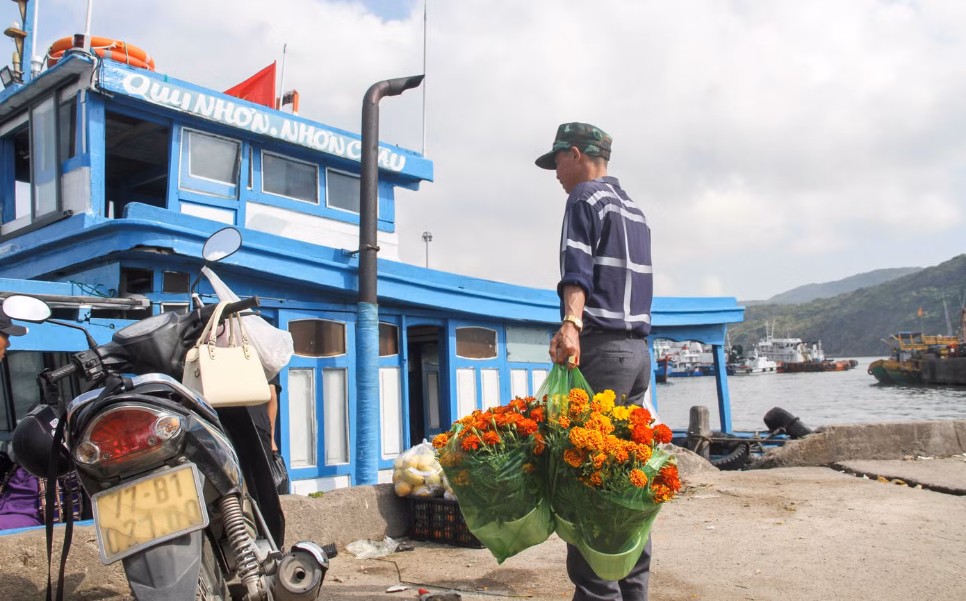 Những chậu hoa vạn thọ được người dân mua đem lên đò mang ra xã đảo Nhơn Châu. (Ảnh: Trương Định)