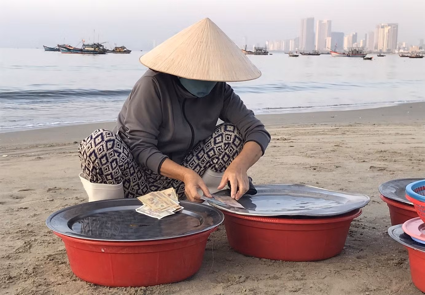 Trời sáng hẳn, chợ đã vãn. Bán hết mấy mẻ tôm cá, bà Lan tranh thủ đếm tiền.“Cũng tạm đủ tiền lo cơm nước trong ngày. Kiếm ra đồng tiền khó lắm, làm nghề nào mà chả vậy. Dù hơi cực đó, nhưng mình phải cố gắng thôi, chỉ mong đủ ăn đủ mặc là vui lắm rồi”. Ảnh: Thu Hương