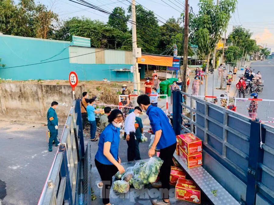 Tại các khu vực bị phong tỏa, tình nguyện viên tích cực hỗ trợ nhu yếu phẩm cho người dân bên trong