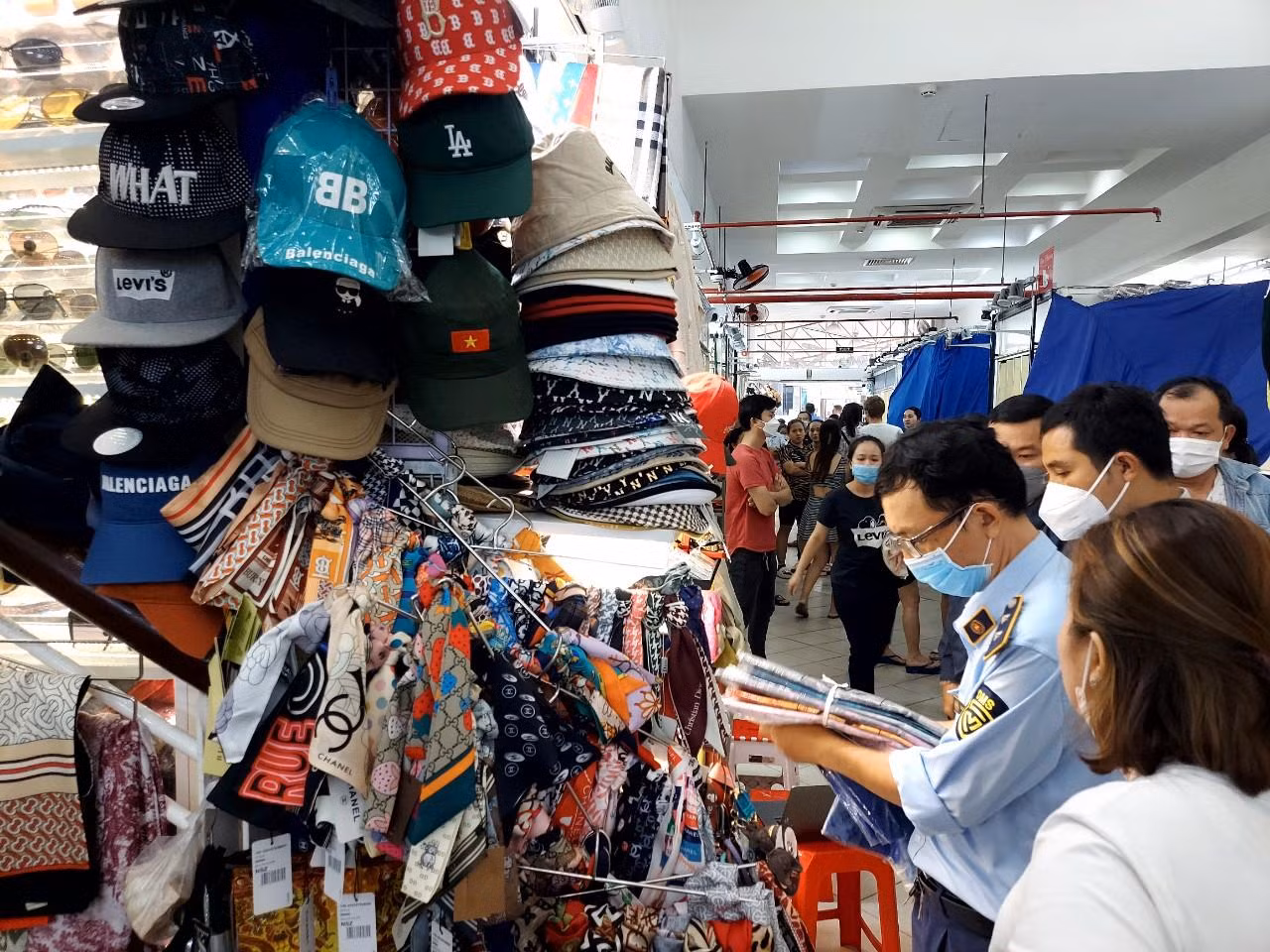 Lực lượng QLTT kiểm tra nguồn gốc một quầy bán hàng quần áo.