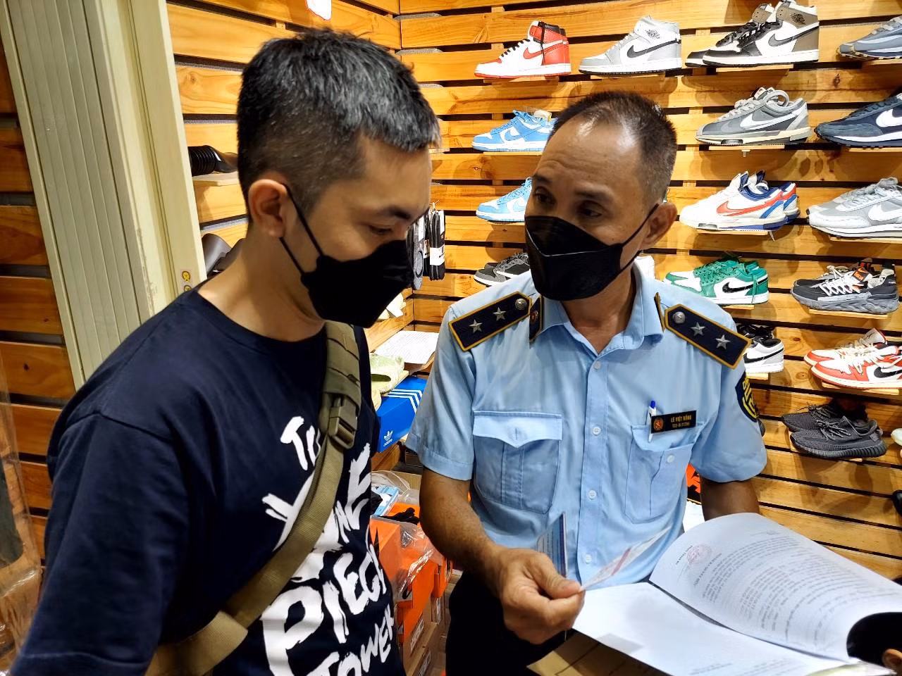 QLTT kiểm tra sổ sách nhập hàng của một tiểu thương