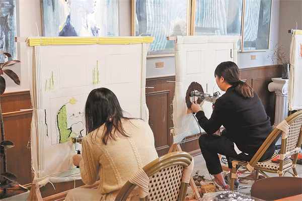 Hai khách hàng thêu sợi tại xưởng thủ công của Jiang Junqi ở Hàng Châu, Chiết Giang (Trung Quốc).