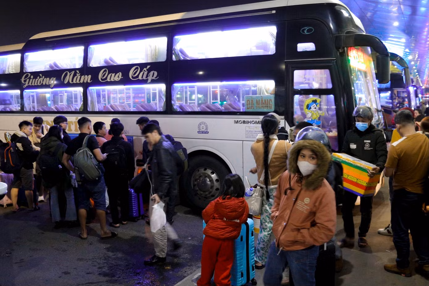 Hàng trăm người mang theo hành lý cồng kềnh để lên xe về quê, nhiều nhân viên nhà xe tất bật xếp hành lý của khách lên xe.