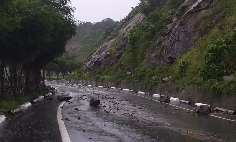 Đất đá sạt lở lăn xuống đường gây nguy hiểm.