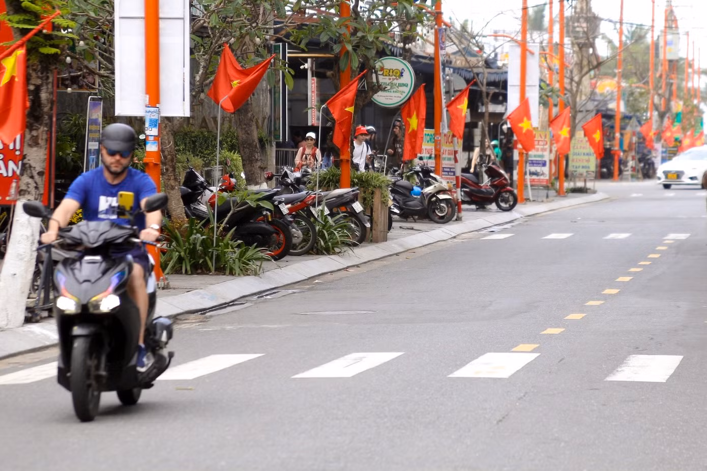Tuyến đường Hoàng Kế Viêm vào "phố Tây" rực rỡ sắc hoa, cờ trang trí. Các cụm hoa dọc tuyến đường được hình thành từ trước Tết đến nay vẫn còn tươi với nhiều màu sắc.