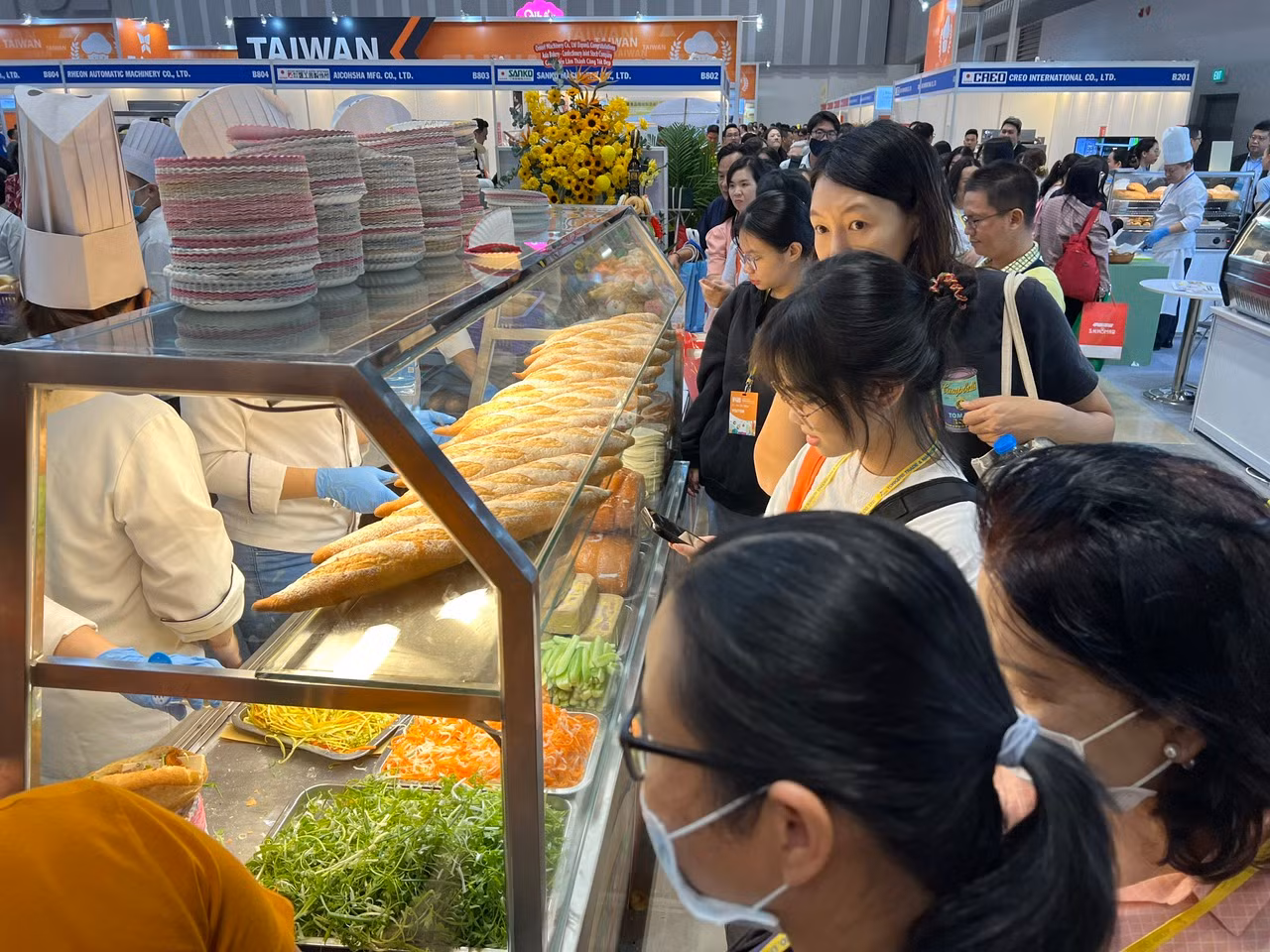 Gần cả trăm người liên tục xếp hàng để được thưởng thức bánh mì kẹp thịt miễn phí. "Tuy dòng người xếp hàng khá dài nhưng chúng tôi không phải chờ đợi lâu, quan trọng là rất vui vì được thưởng thức ổ bánh mì rất thơm ngon, chất lượng và có giá 0 đồng. Khách muốn ăn bao nhiêu cũng được, chỉ cần chịu khó xếp hàng" - anh Bình (khách tham quan) hào hứng nói.