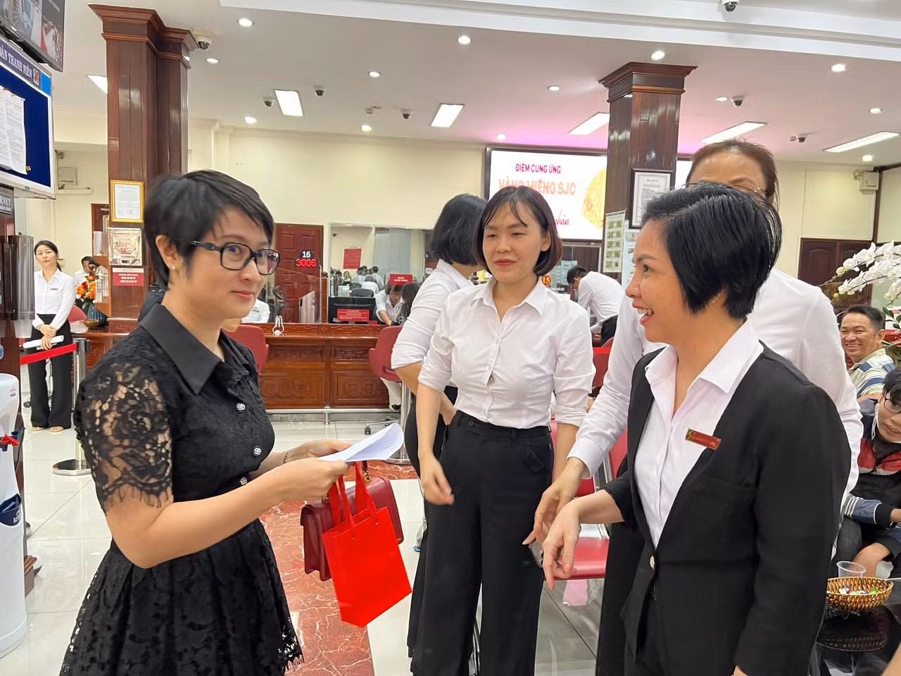 Lãnh đạo ngân hàng Agribank chúc mừng vị khách đầu tiên mua vàng trong ngày đầu mở bán.
